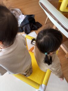 滑り台に二人で座る兄妹の後ろ姿