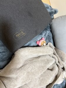 ソファに毛布をかけて赤ちゃんマンの人形を寝かせた様子