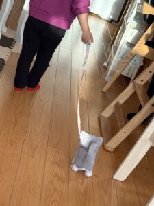 ぬいぐるみ猫を散歩させる子どもの後ろ姿