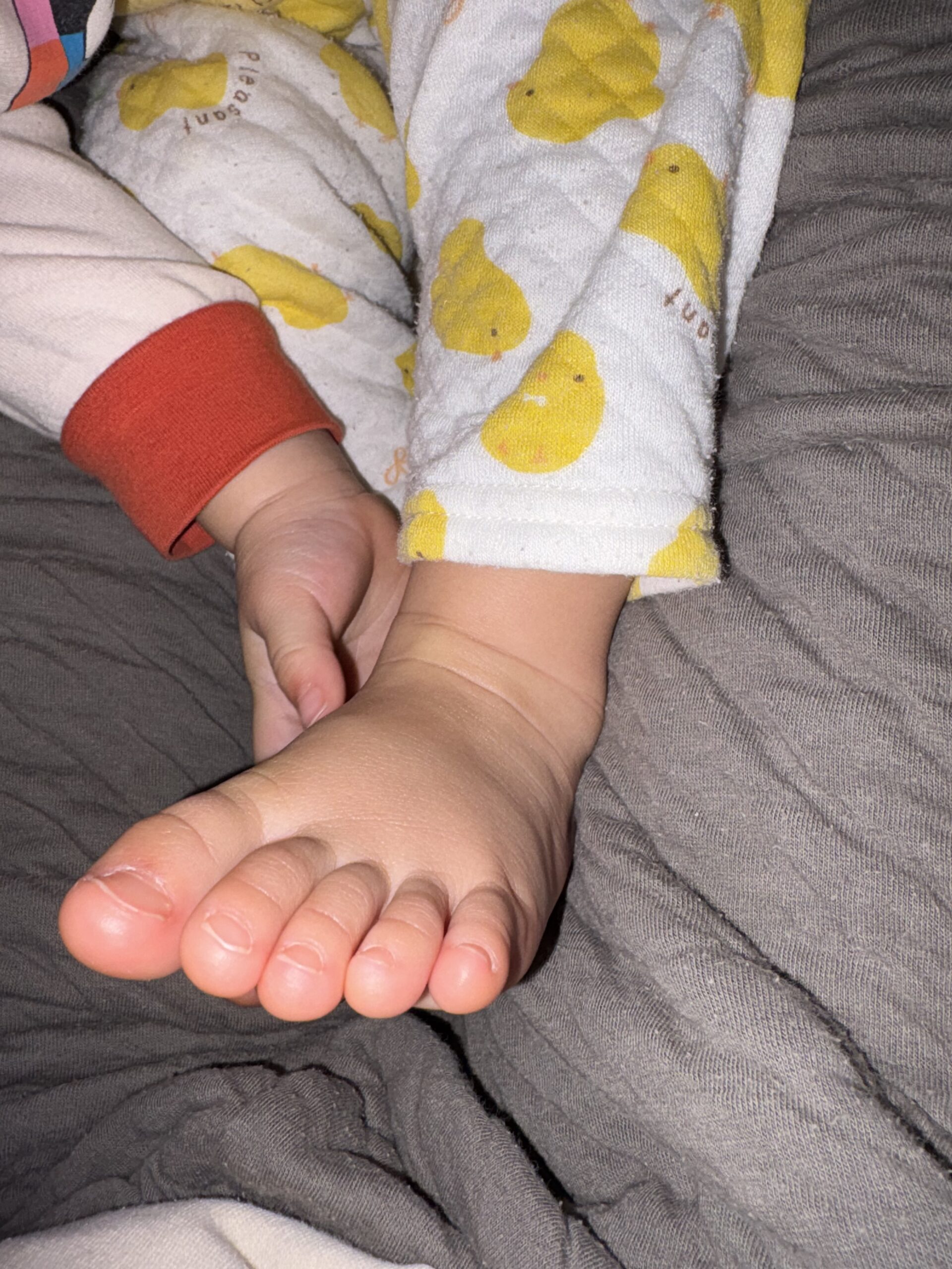 旅行後にママから離れず甘える下の子の小さな足