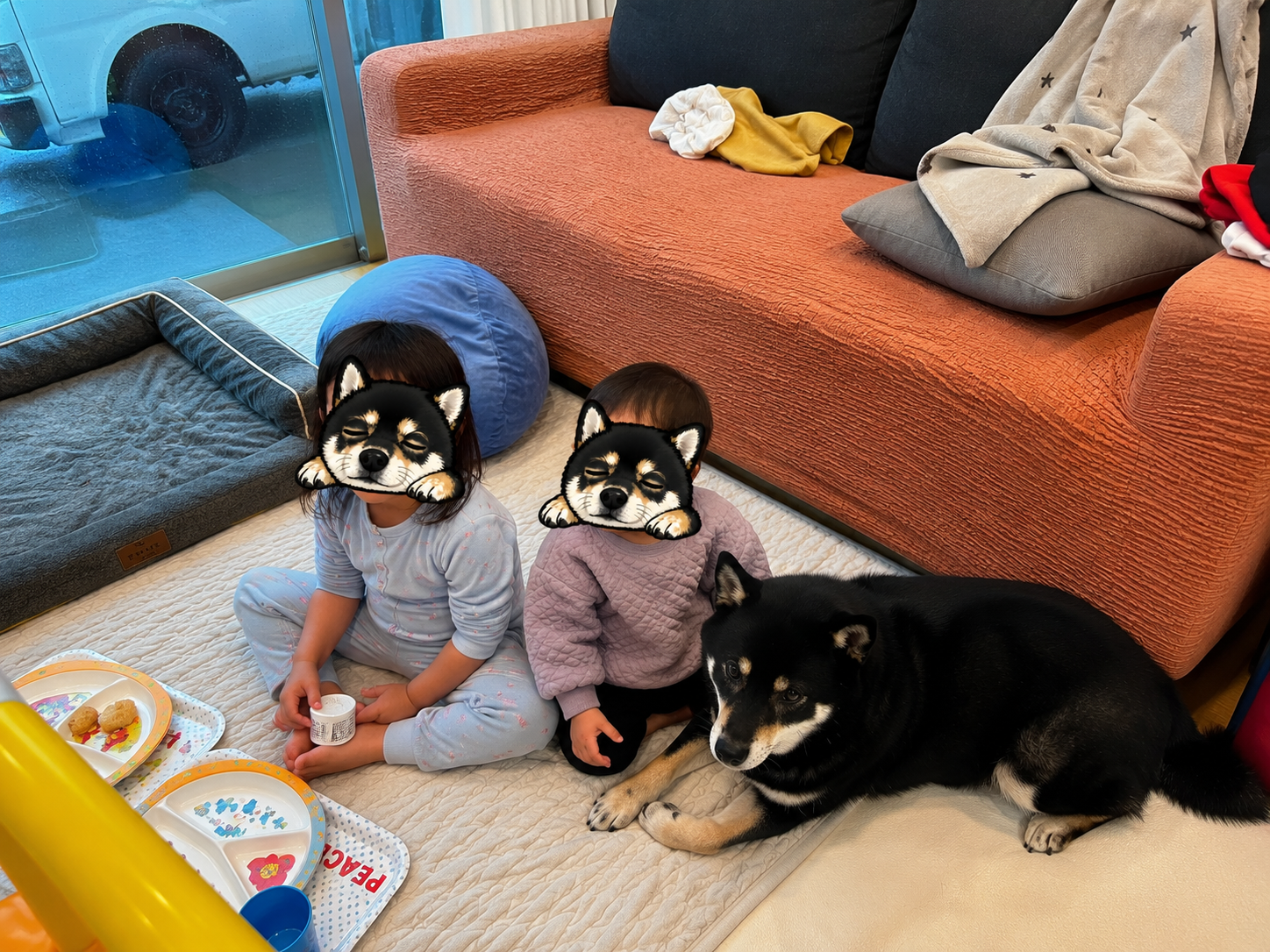 リビングのマットでくつろぐ子ども2人と黒柴まめ